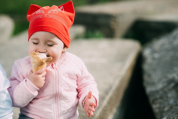 Petite fille à l'extérieur dans le village de manger de la crème glacée très goulûment