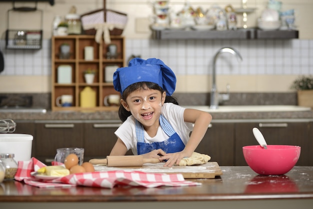 Petite fille à faire de la pâte