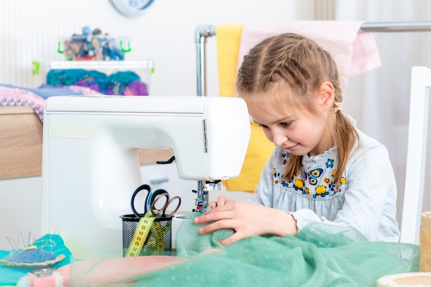 Petite fille faisant de l'artisanat à la machine à coudre