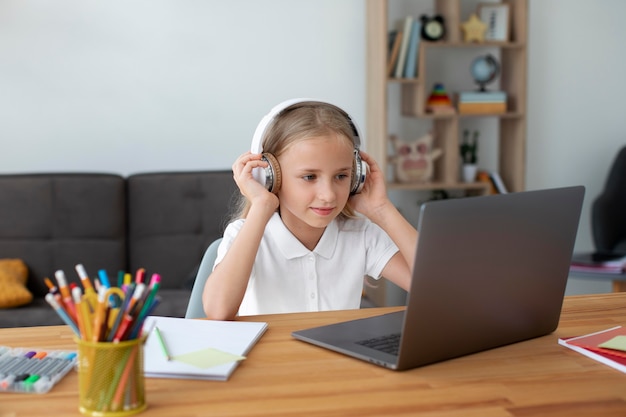 Petite fille faisant des cours en ligne à domicile