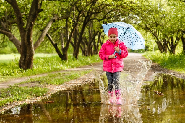 Petite fille faisant du vélo dans une flaque d'eau