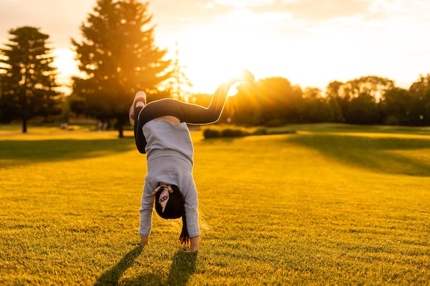 Photo petite fille faisant des exercices de gymnastique dans le parc.