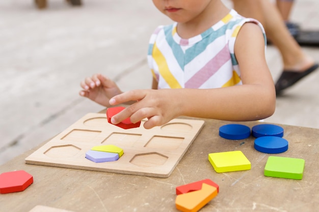 Petite fille faisant un puzzle en bois coloré