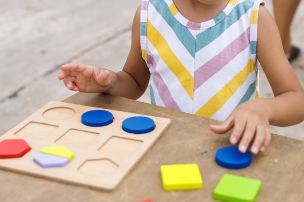 Petite fille faisant un puzzle en bois coloré