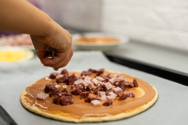 petite fille fait de la pizza à la maison