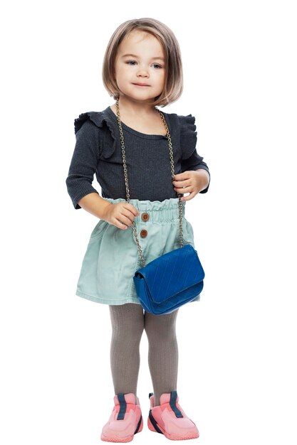 Petite fille fashionista avec un beau sac de mère. Style et mode. Isolé sur fond blanc. Pleine hauteur. Verticale.