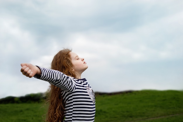 Petite fille ferma les yeux et respirant avec de l&#39;air frais.