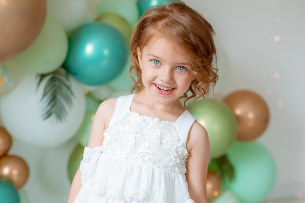 Une petite fille fête son anniversaire sur fond de ballons