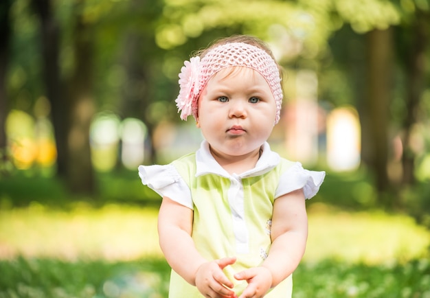 Petite fille avec fleur dans les cheveux dans le parc