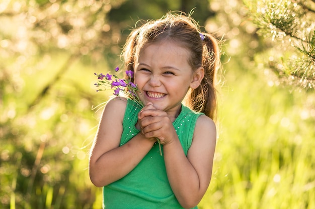 petite fille avec des fleurs cloches sur la nature en été