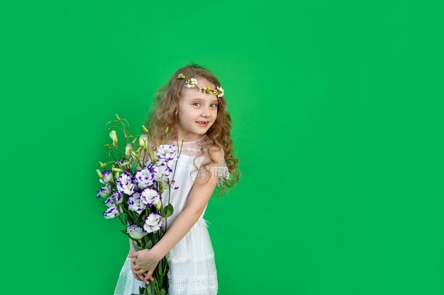 Petite fille avec des fleurs sur fond vert