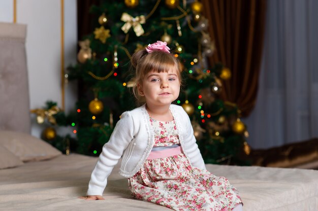 Petite fille sur fond d'arbre de Noël.