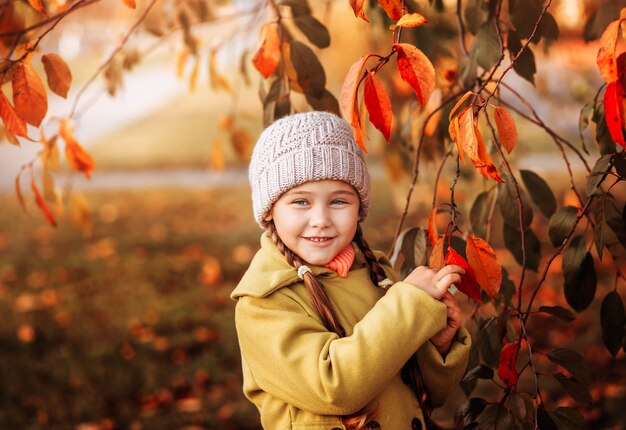 Petite fille sur fond de feuilles d'automne orange. Portrait d'automne