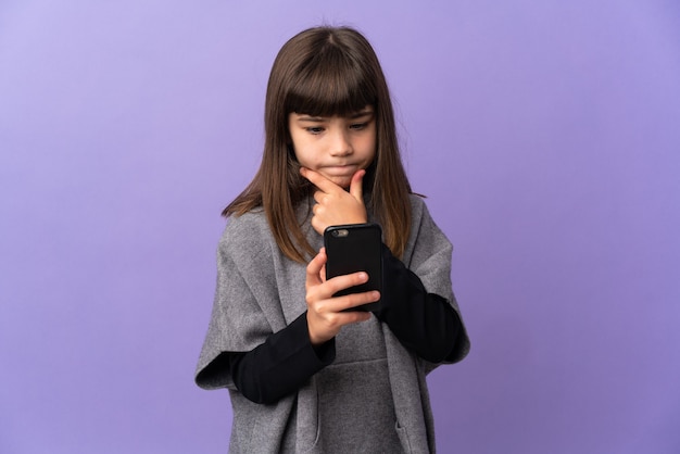 Petite fille sur fond isolé pensant et envoyant un message