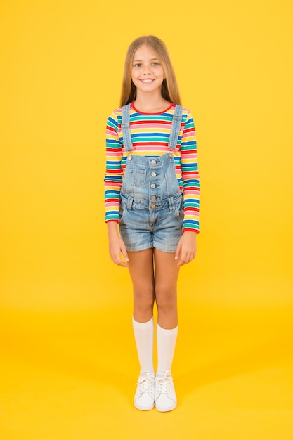 Petite fille fond jaune été enfant mode Enfant humeur heureuse Fille visage souriant Universal childrens day enfance bonheur gai hipster fille vêtements colorés concept optimiste