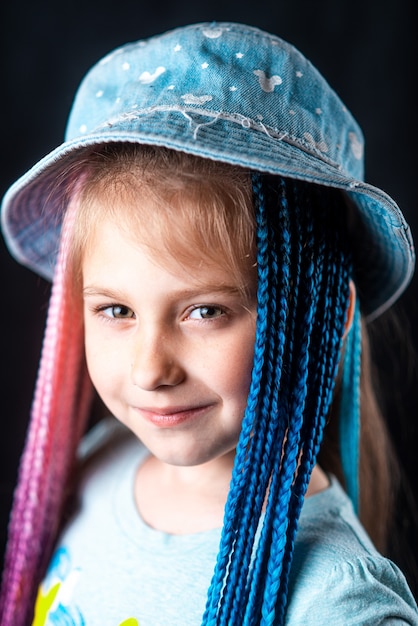 Petite fille sur fond noir avec des bandes élastiques afro bleues et roses tresses sur une bande élastique ...