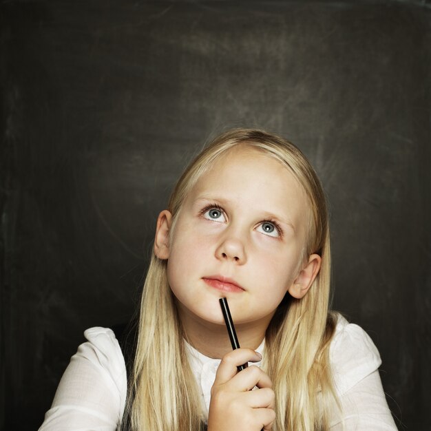 Petite fille sur fond de tableau noir