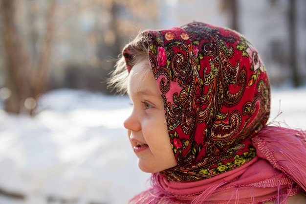 Petite fille en foulard sur fond de paysage d'hiver