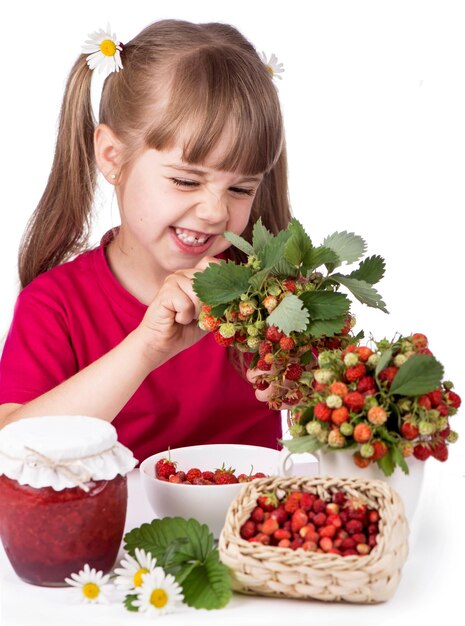 Petite fille avec des fraises de fleurs et de la confiture sucrée sur fond blanc