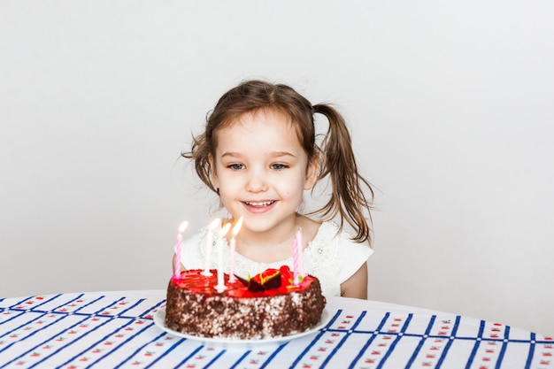 Petite fille et gâteau d'anniversaire, souffle des bougies, fait un vœu, gâteau et bougies, cadeaux d'anniversaire, famille, maman et papa