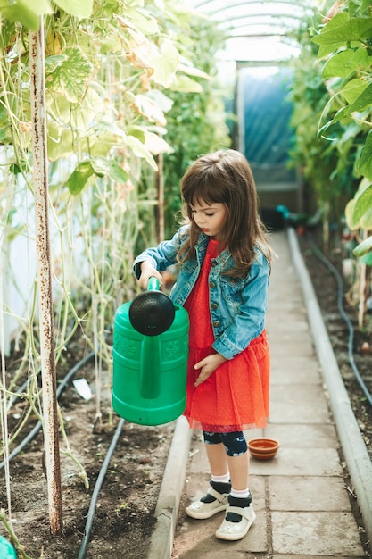 Petite fille avec grand arrosoir