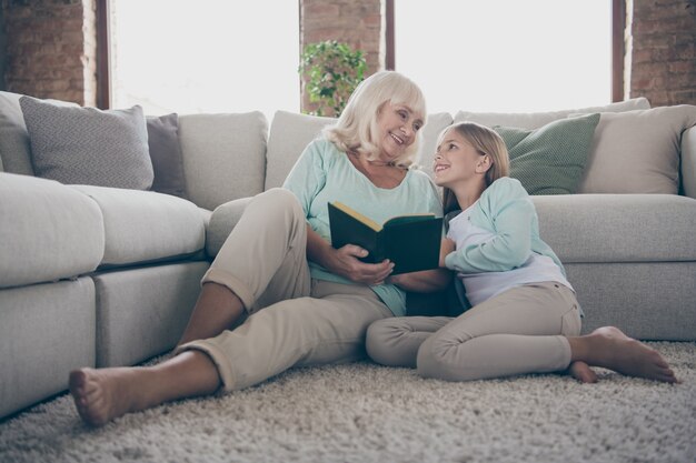 Petite fille et grand-mère assise sur le canapé