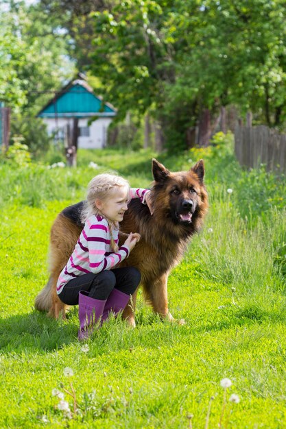 Petite fille avec gros chien berger