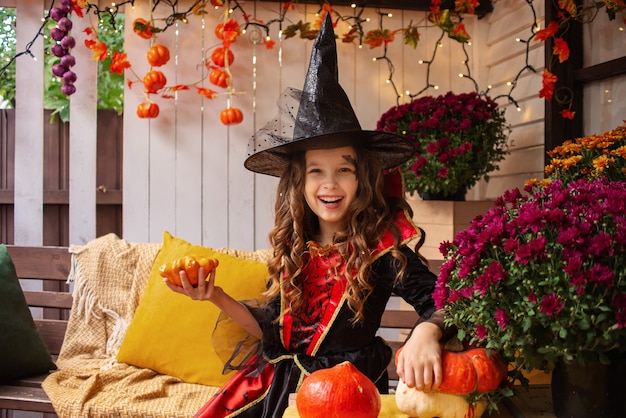 petite fille habillée en sorcière s'amuse avec halloween