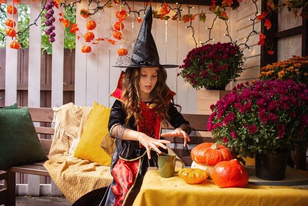 petite fille habillée en sorcière s'amuse avec halloween