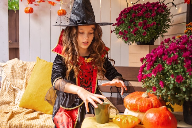 petite fille habillée en sorcière s'amuse avec halloween