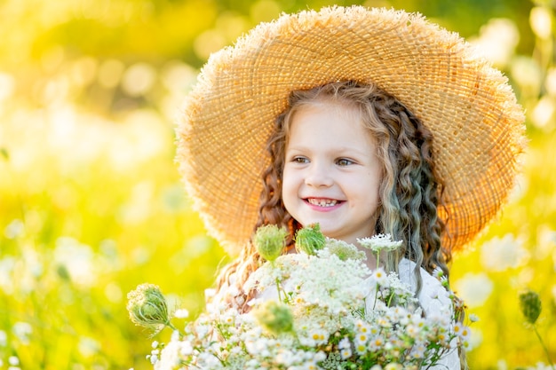 Petite fille heureuse avec un chapeau sur le terrain
