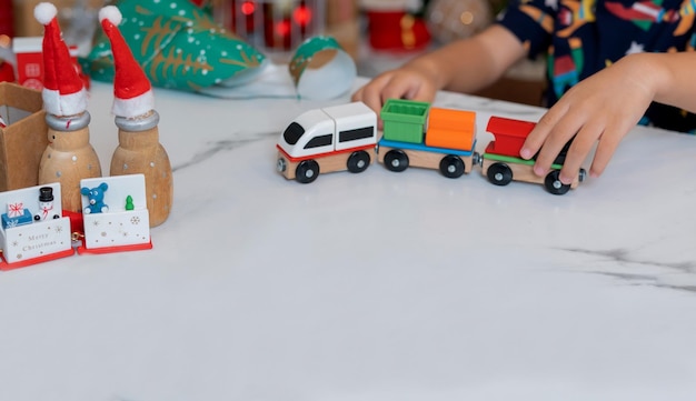 Petite fille heureuse jouant au jouet de train et s'amuser à la fête de Noël dans le salon avec décoration à la maison.