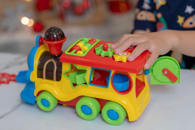 Petite fille heureuse jouant au jouet de train et s'amuser à la fête de Noël dans le salon avec décoration à la maison.