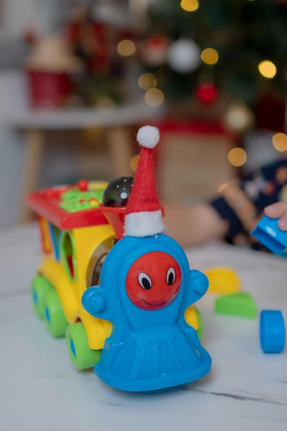 Photo petite fille heureuse jouant au jouet de train et s'amuser à la fête de noël dans le salon avec décoration à la maison.