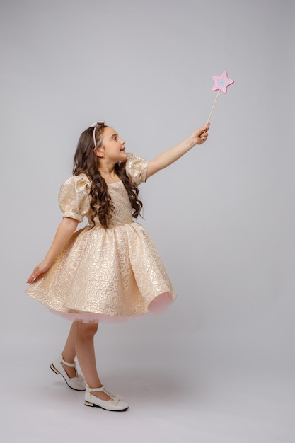 Petite Fille à L'image D'une Fée Avec Une Baguette Magique Sur Fond Blanc