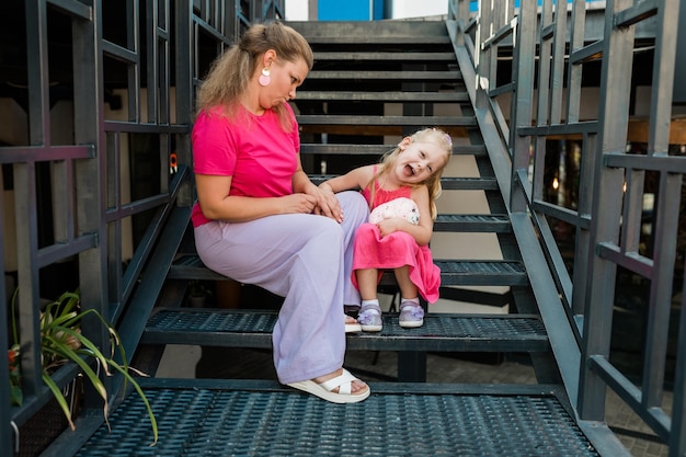 Photo une petite fille avec un implant cochléaire avec sa mère passe du temps à l'extérieur avec une déficience auditive et une surdité