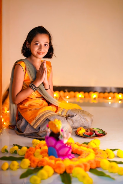 Petite fille indienne mignonne priant et célébrant le festival de diwali.