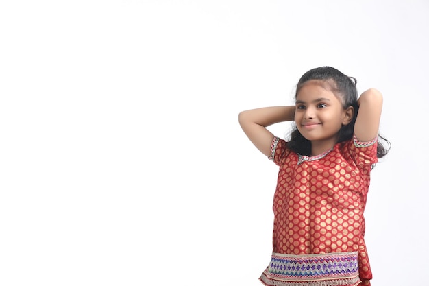 Photo petite fille indienne en tenue traditionnelle et donnant une expression sur fond blanc