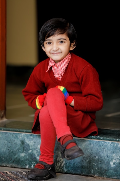 Petite fille indienne en uniforme scolaire et montrant l'expression