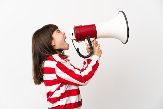 Petite fille isolée sur fond blanc criant à travers un mégaphone pour annoncer quelque chose en position latérale