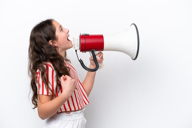 Petite fille isolée sur fond blanc criant à travers un mégaphone pour annoncer quelque chose en position latérale