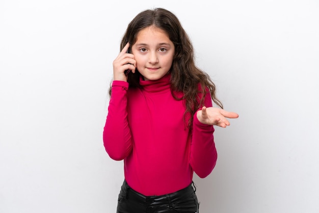 Petite fille isolée sur fond blanc en gardant une conversation avec le téléphone portable avec quelqu'un