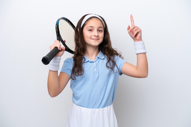 Petite fille isolée sur fond blanc jouant au tennis et pointant vers le haut