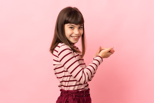 Petite fille isolée sur un mur rose applaudissant