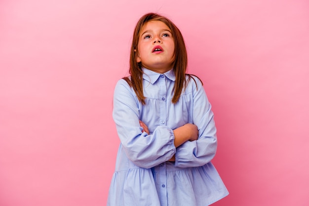 Petite fille isolée sur un mur rose fatigué d'une tâche répétitive