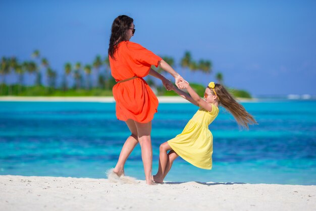 Petite fille et jeune maman pendant les vacances à la plage