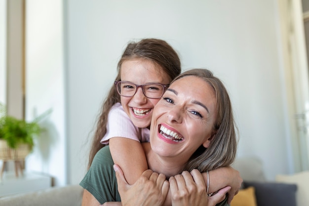 Petite fille jeune mère face webcam vue rapprochée. Une adorable petite fille utilise un smartphone pour s'amuser avec sa sœur aînée en faisant des selfies, les vloggers enregistrent un nouveau vlog, profitent d'un concept d'activité amusant