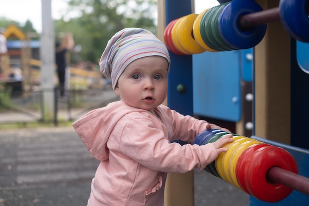 Petite fille jouant avec des anneaux colorés sur l'aire de jeux