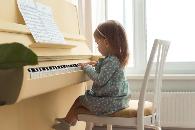petite fille jouant au piano jaune