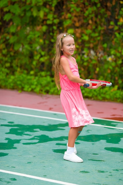 Petite fille jouant au tennis sur le court